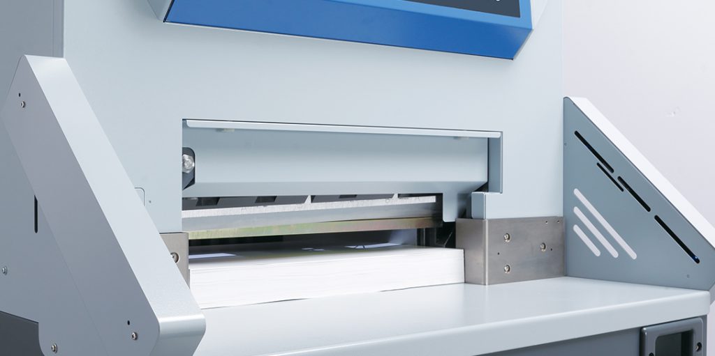 Front view of Horizon APC-450 cutter table with blade over stacked paper – precision alignment and durable work surface for professional trimming.