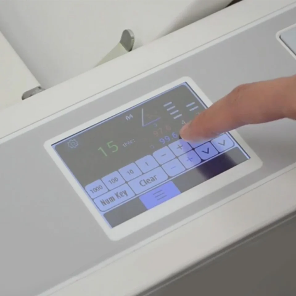 MBM 508A Paper Folder touchscreen interface with a user adjusting settings on the digital control panel.