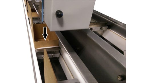 Close-up of Baum Print/Fold/Stage/Document Insertion system showing document staging area with arrow indicating paper feed path between metal guide rails and components