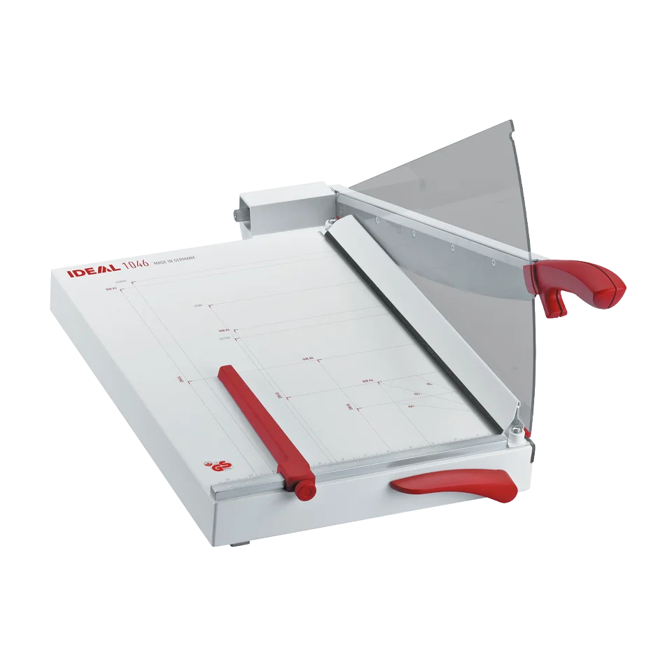 MBM Triumph 1046 tabletop trimmer featuring a red ergonomic handle, precision blade, adjustable back gauge, and clear safety guard on a printed alignment grid.