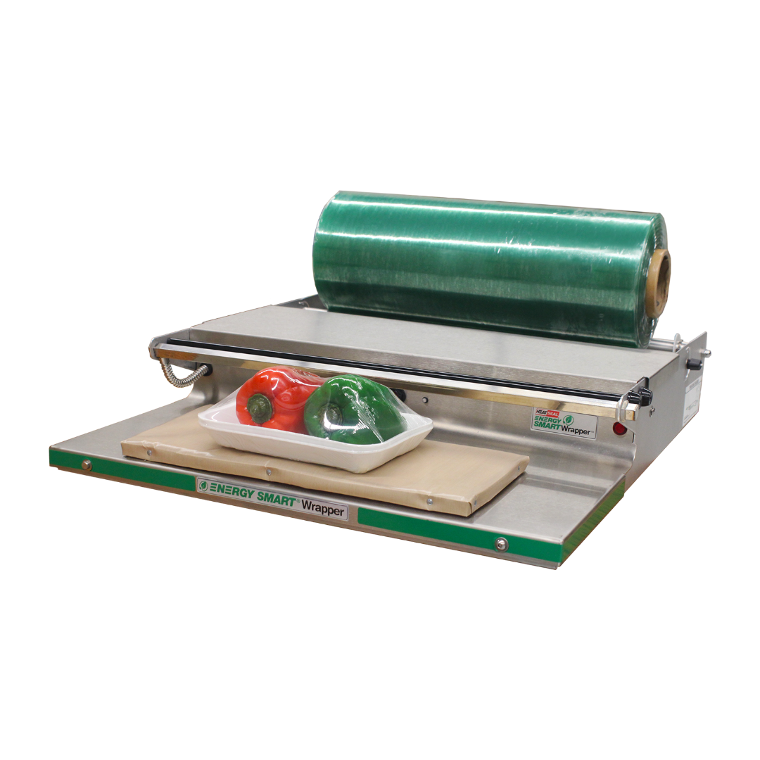 Heat Seal 700ES-E Energy Smart food wrapper with green film roll and wrapped tray of peppers on heated pad