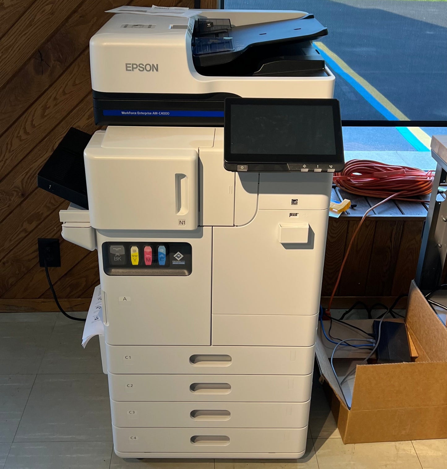 Epson printer in a room with a window showing an outdoor view.