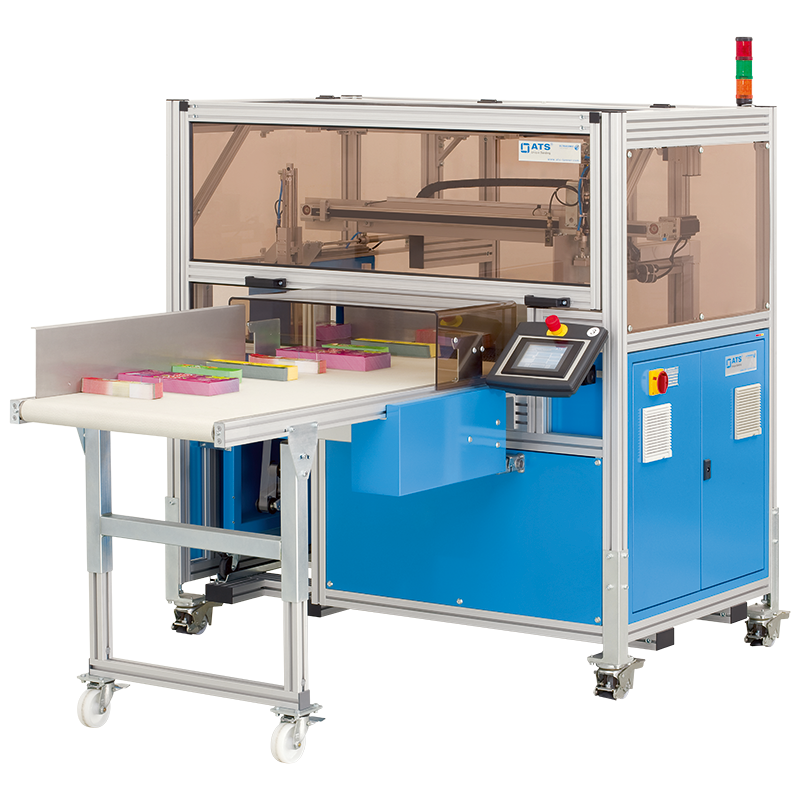 Felins US-2000 CSW-DMS automatic banding system with integrated stacking, shown with colorful retail product stacks on the conveyor and touchscreen interface.